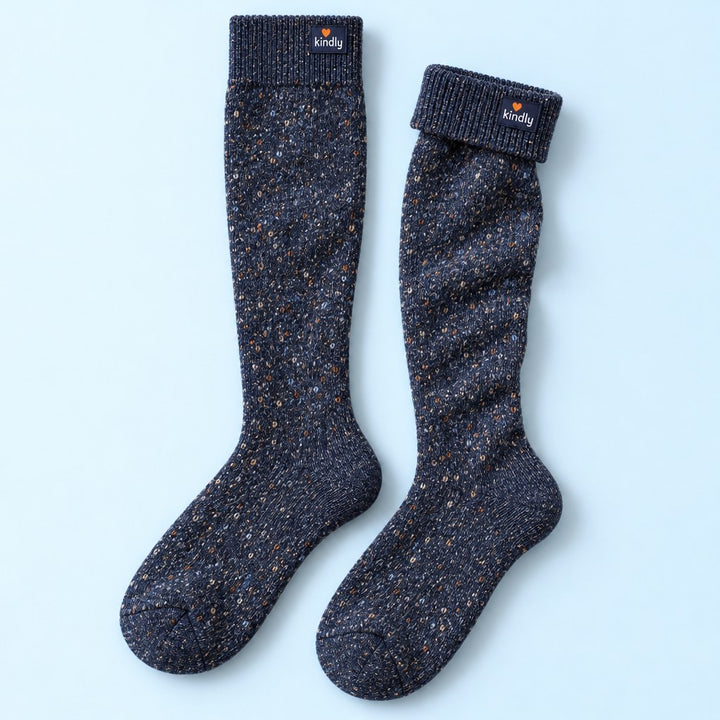 Studio flat lay of one pair of Kindly Cabin Socks, thick merino over-the-calf socks in navy heather